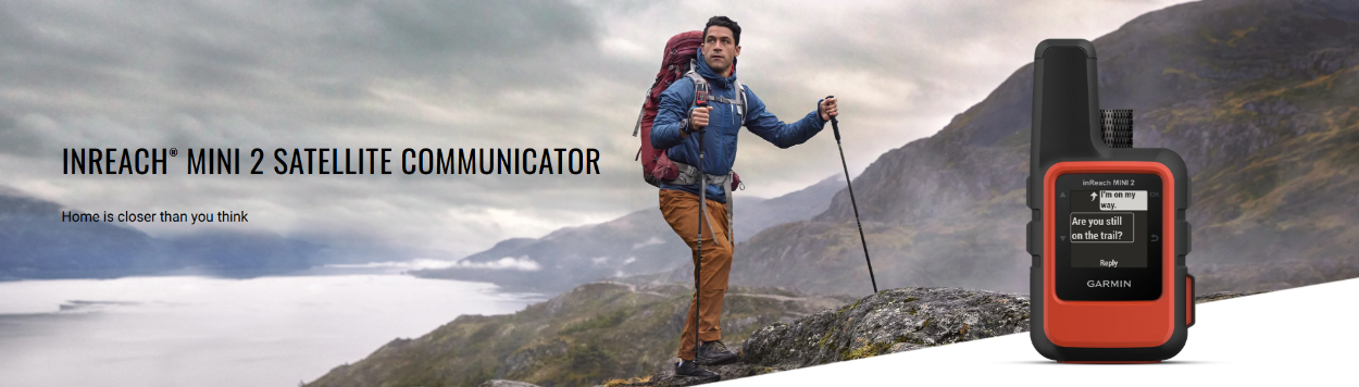 Hiker with a backpack and trekking pole standing on a mountain with INREACH Mini 2 satellite communicator displayed.